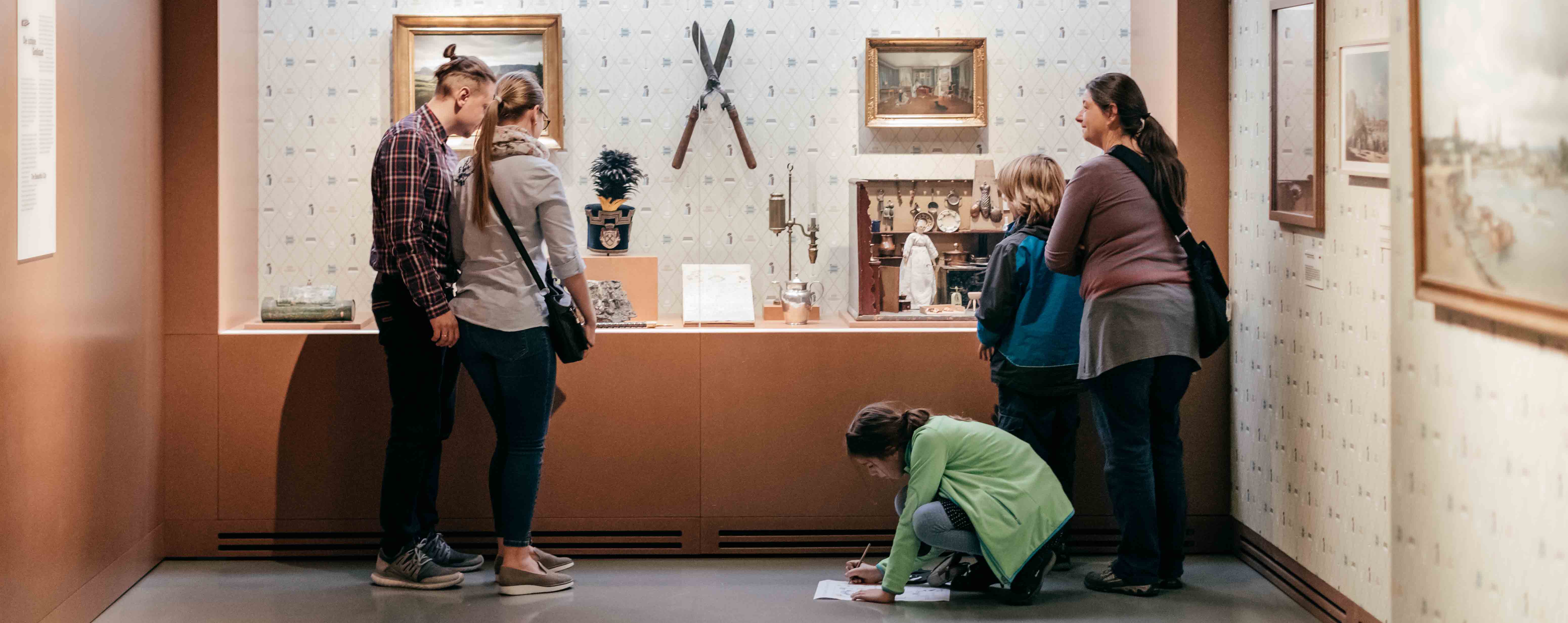 Eine Familie betrachtet eine Vitrine in der Dauerausstellung.